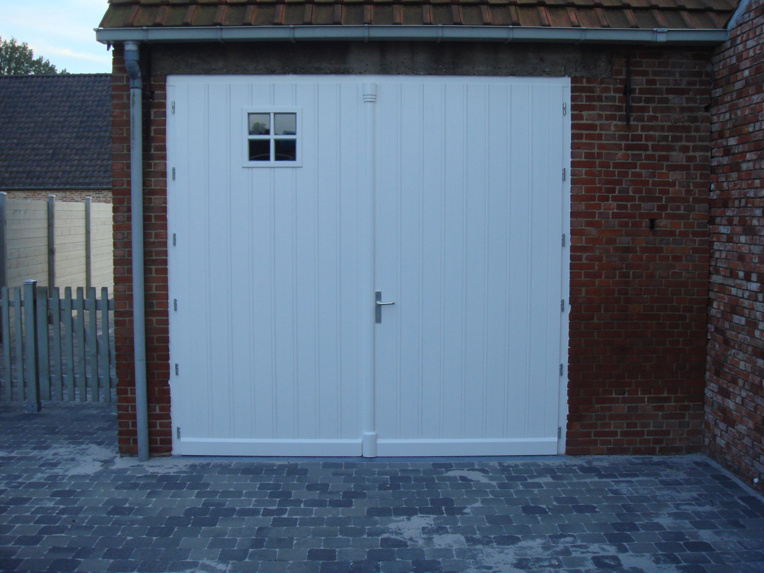 014 - Naar buiten opendraaiende garagepoort in afzelia