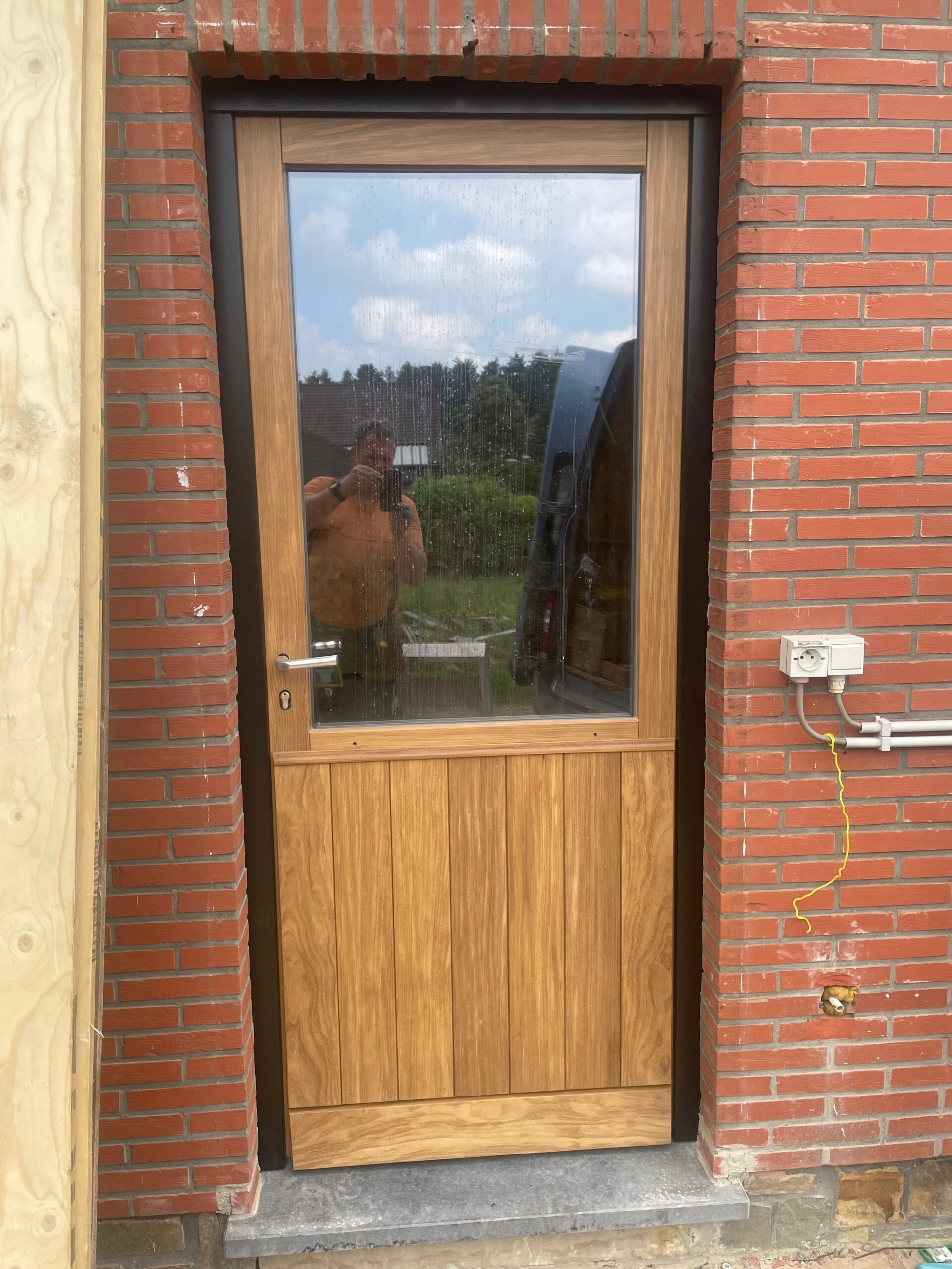 082 - Achterdeur in afrormosia (transparant behandeld) en buitenkader in padoek (behandeld in ralkleur)